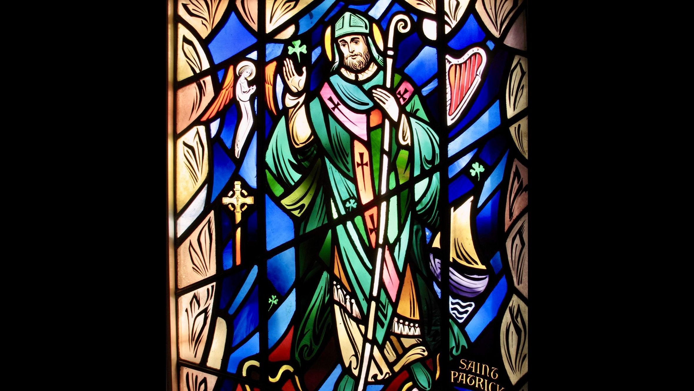 Stained glass depiction of Saint Patrick holding a staff, symbolizing his role in spreading Christianity across Ireland