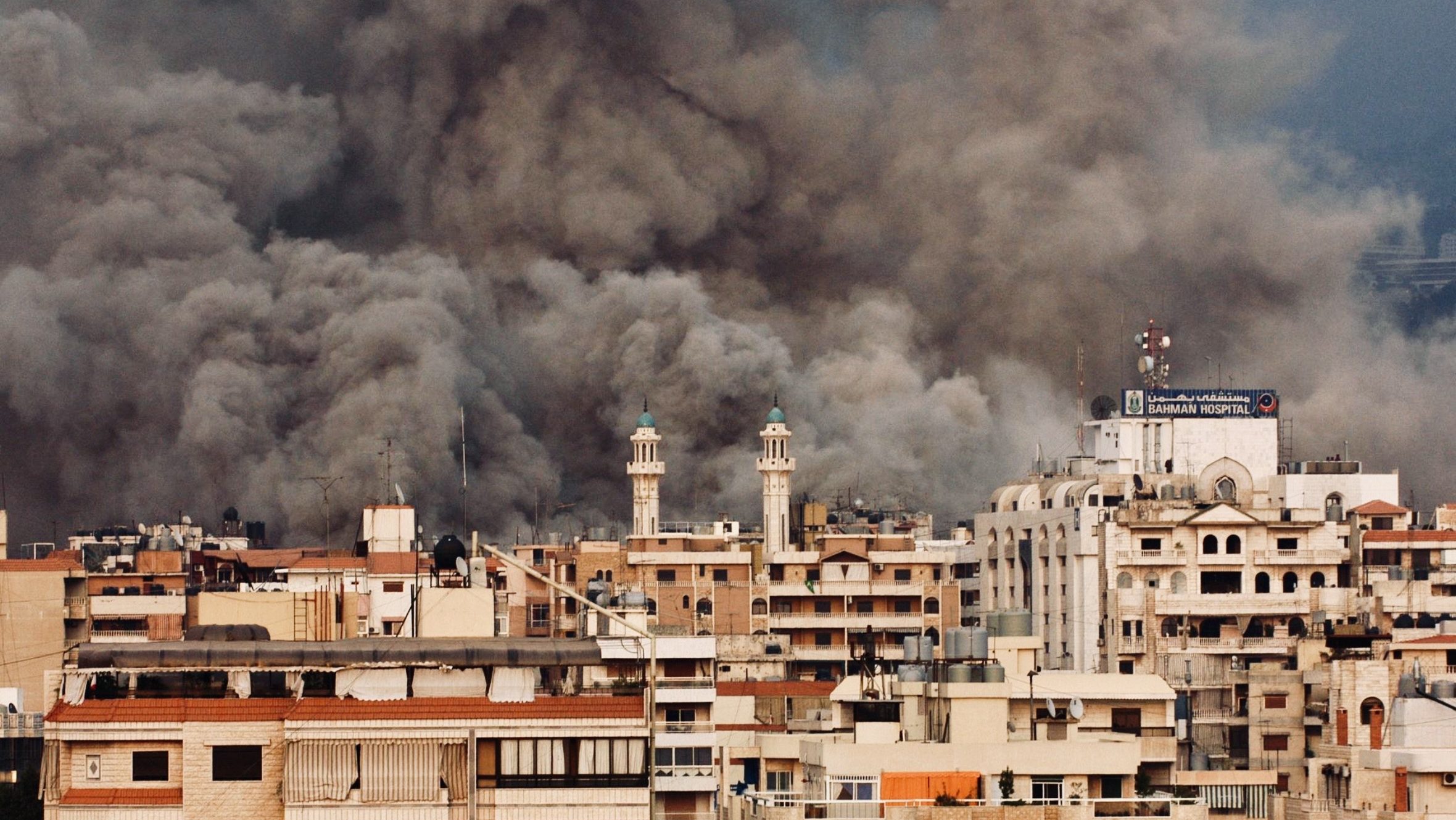Smoke rising over buildings in Beirut following airstrikes during escalating conflict involving Israel and Hezbollah.