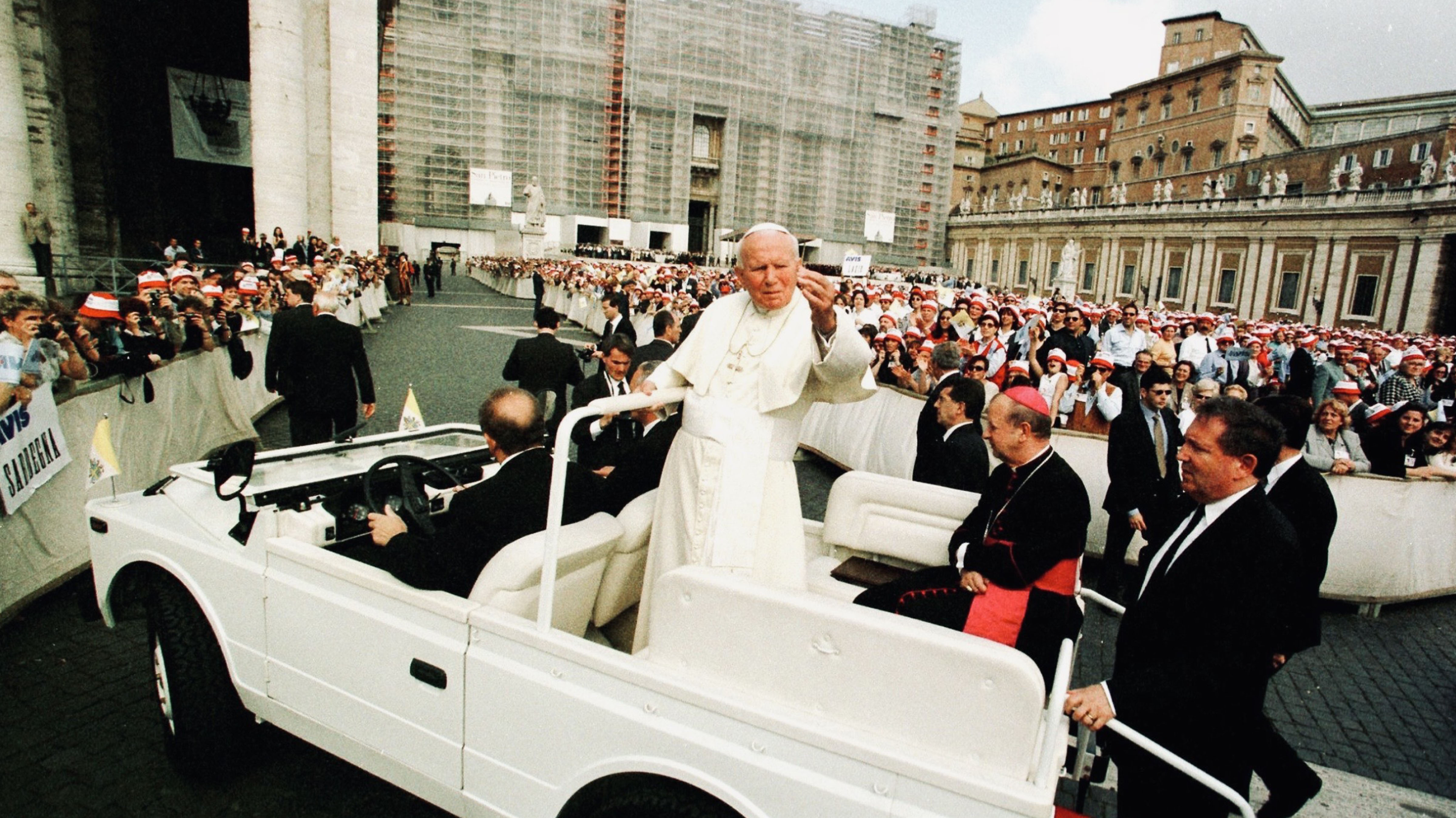 Pope John Paul II riding through St. Peter’s Square in Vatican City during a public appearance surrounded by large crowds.