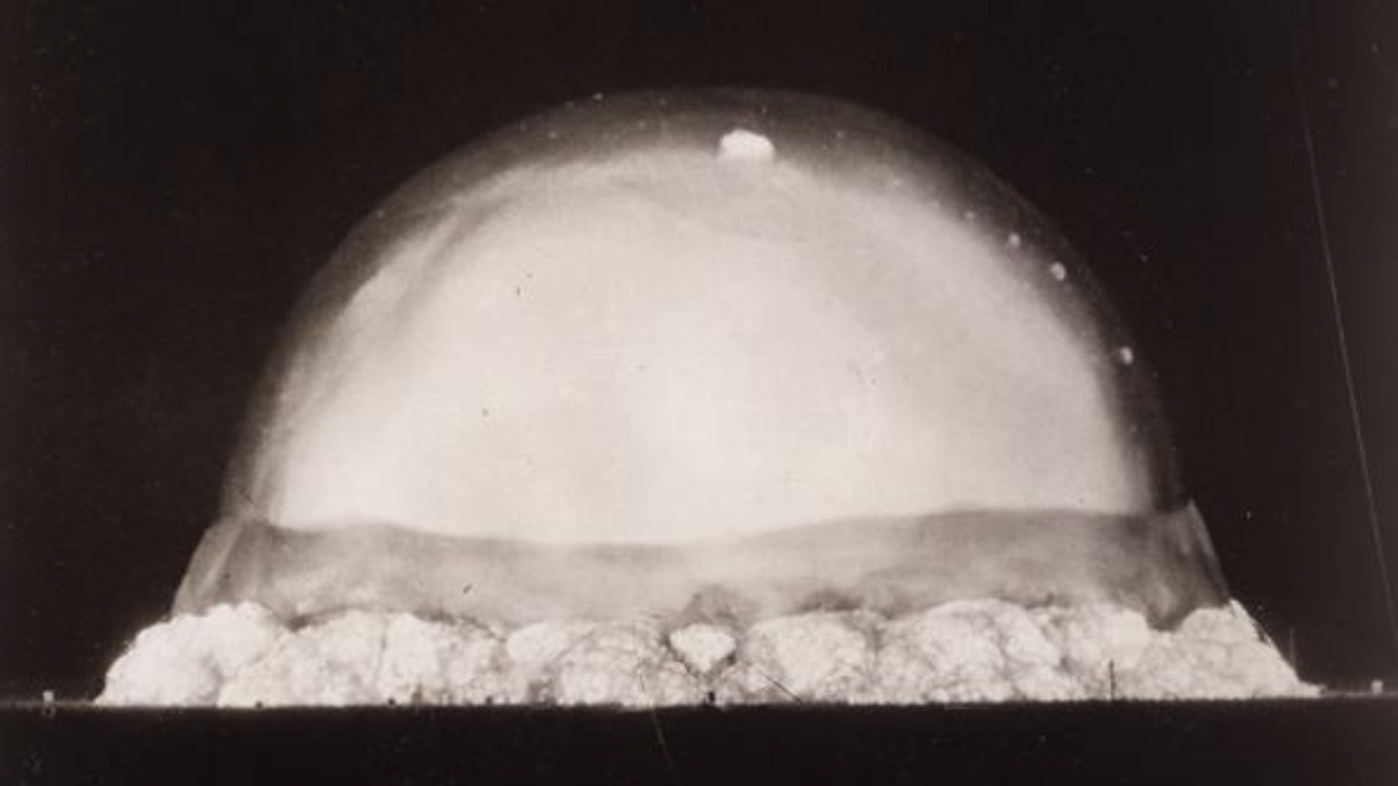 The first atomic bomb test, known as the Trinity Test, moments after detonation on July 16, 1945, showing the expanding fireball over the New Mexico desert.