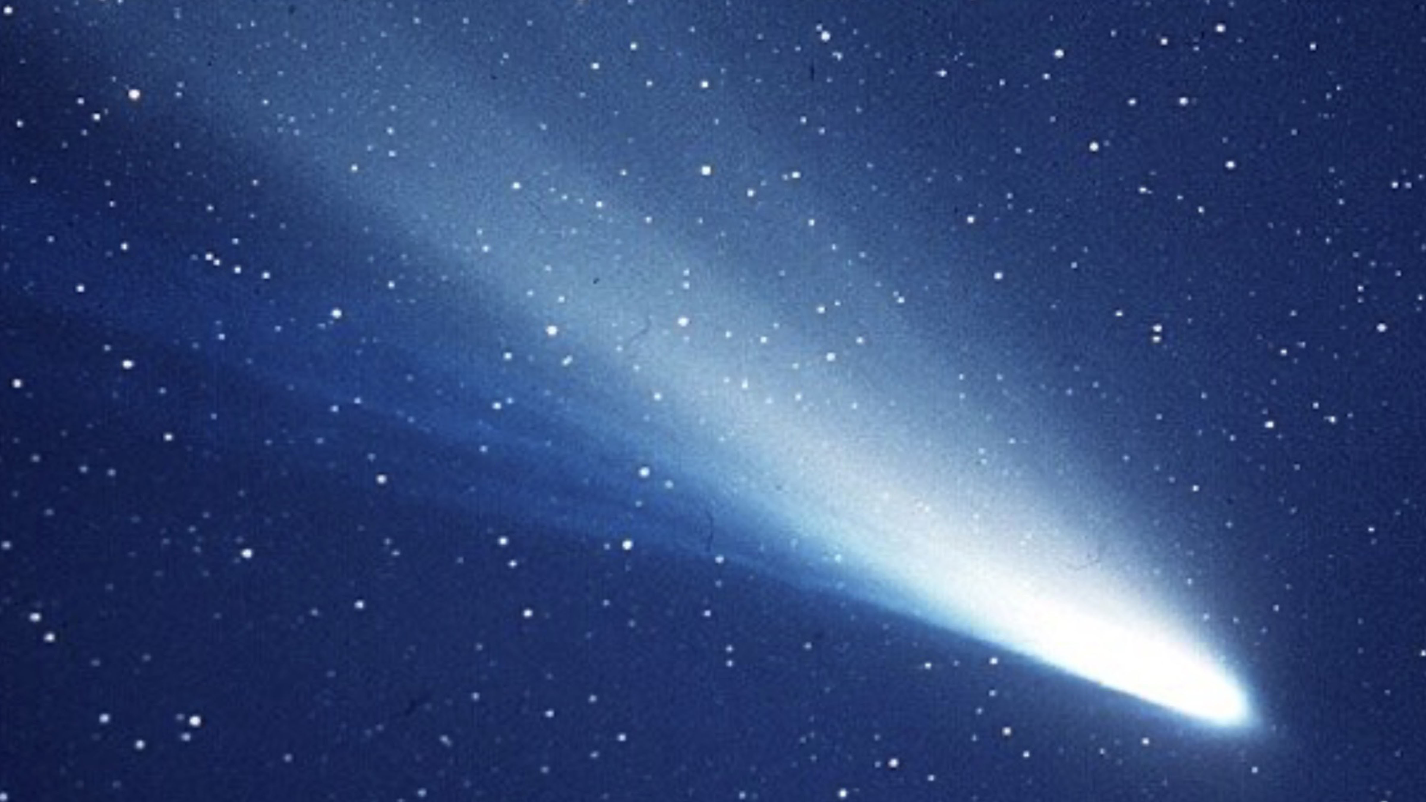 Comet Hale–Bopp streaks across the night sky, displaying its bright coma and long dust and ion tails during its 1997 passage through the inner Solar System.