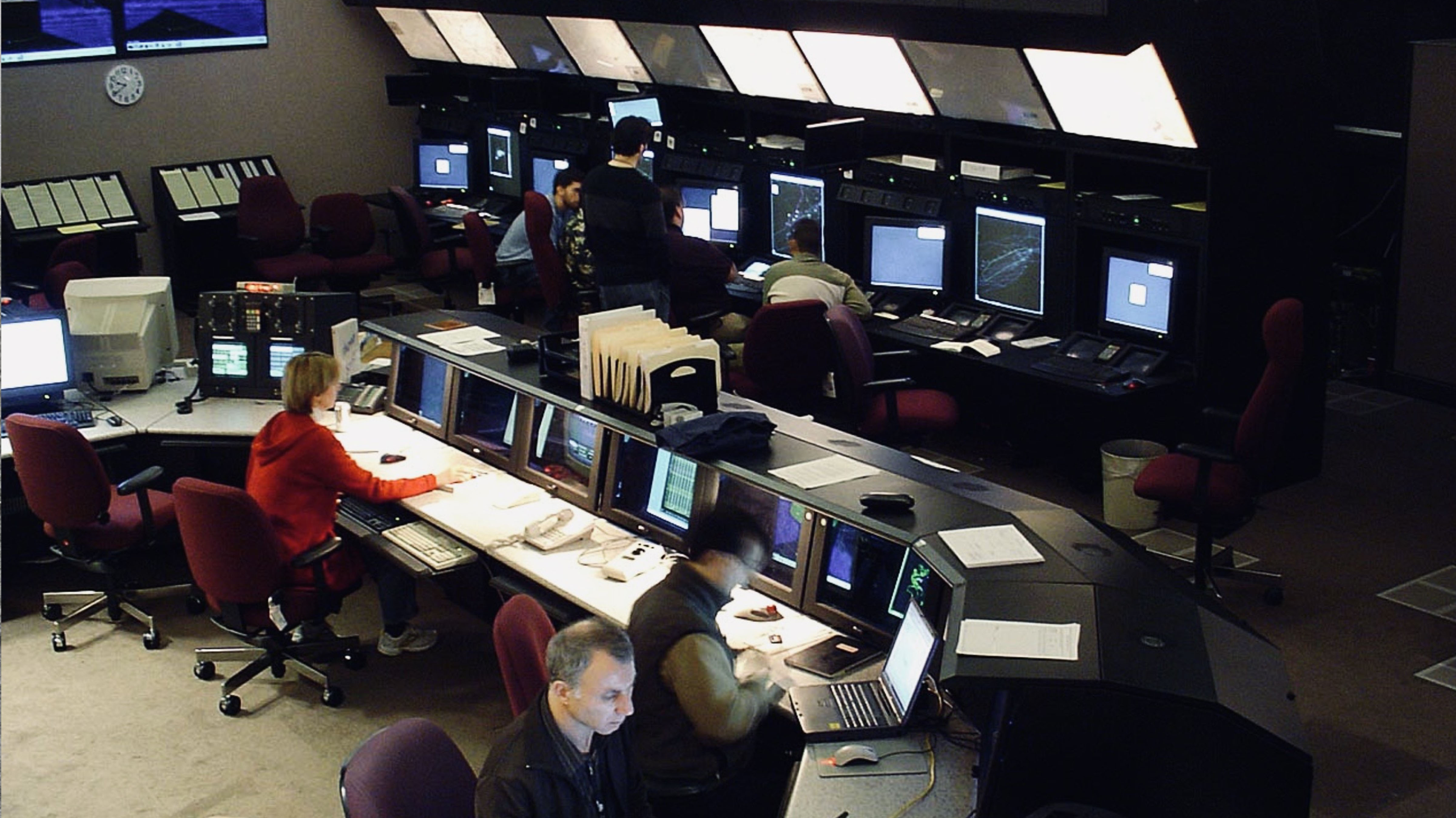 Air traffic controllers monitor aircraft movements at radar workstations inside a U.S. air route traffic control center.