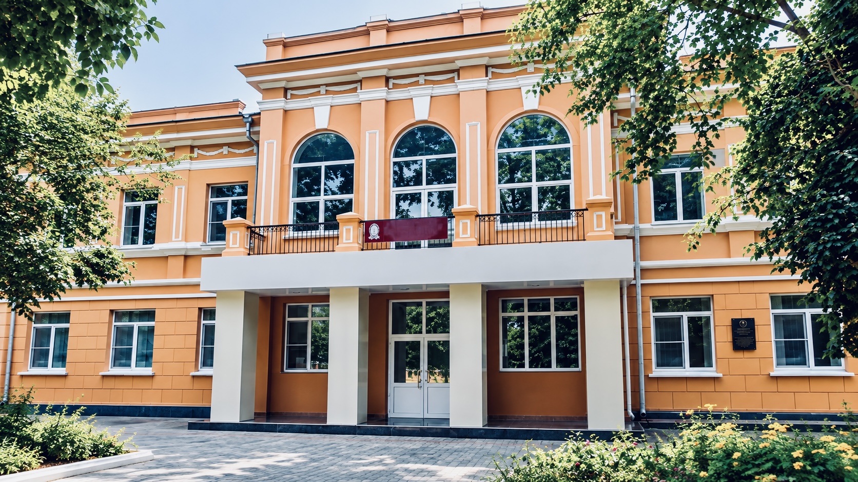 Exterior of the Irkutsk Anti-Plague Research Institute in Russia, showing its peach-coloured façade, arched windows and main entrance.